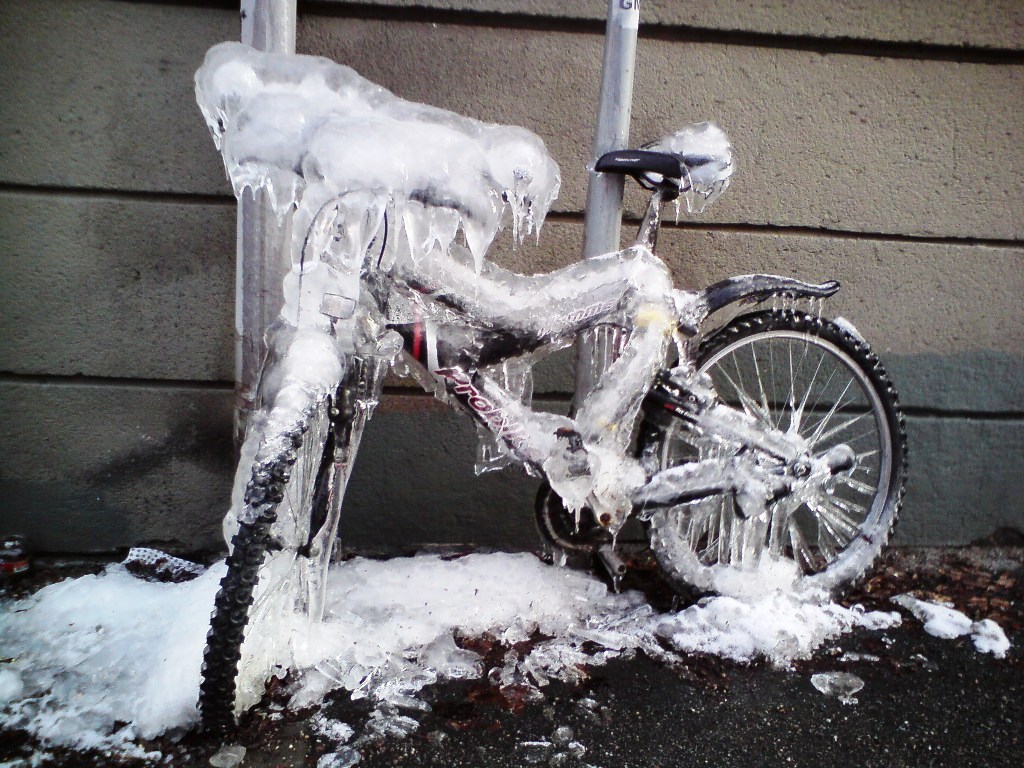 En cykel helt nedisad. Istappar hänger från stången.
