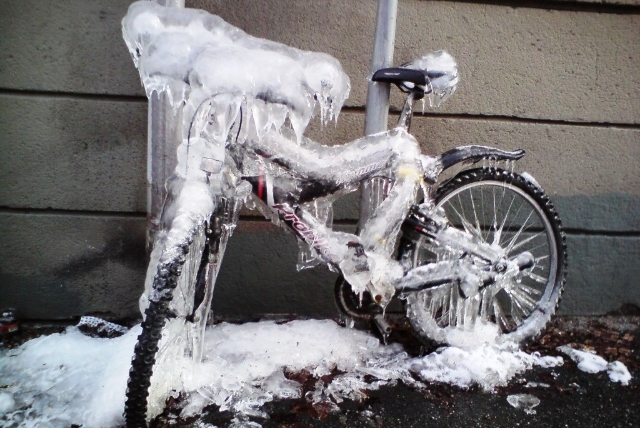 En cykel helt nedisad. Istappar hänger från stången.