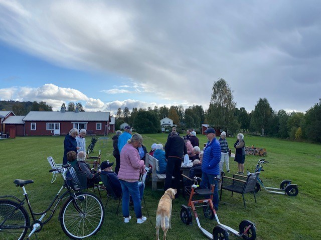 Besökare i bakgrunden, en brun cykel och en gul hund i förgrunden